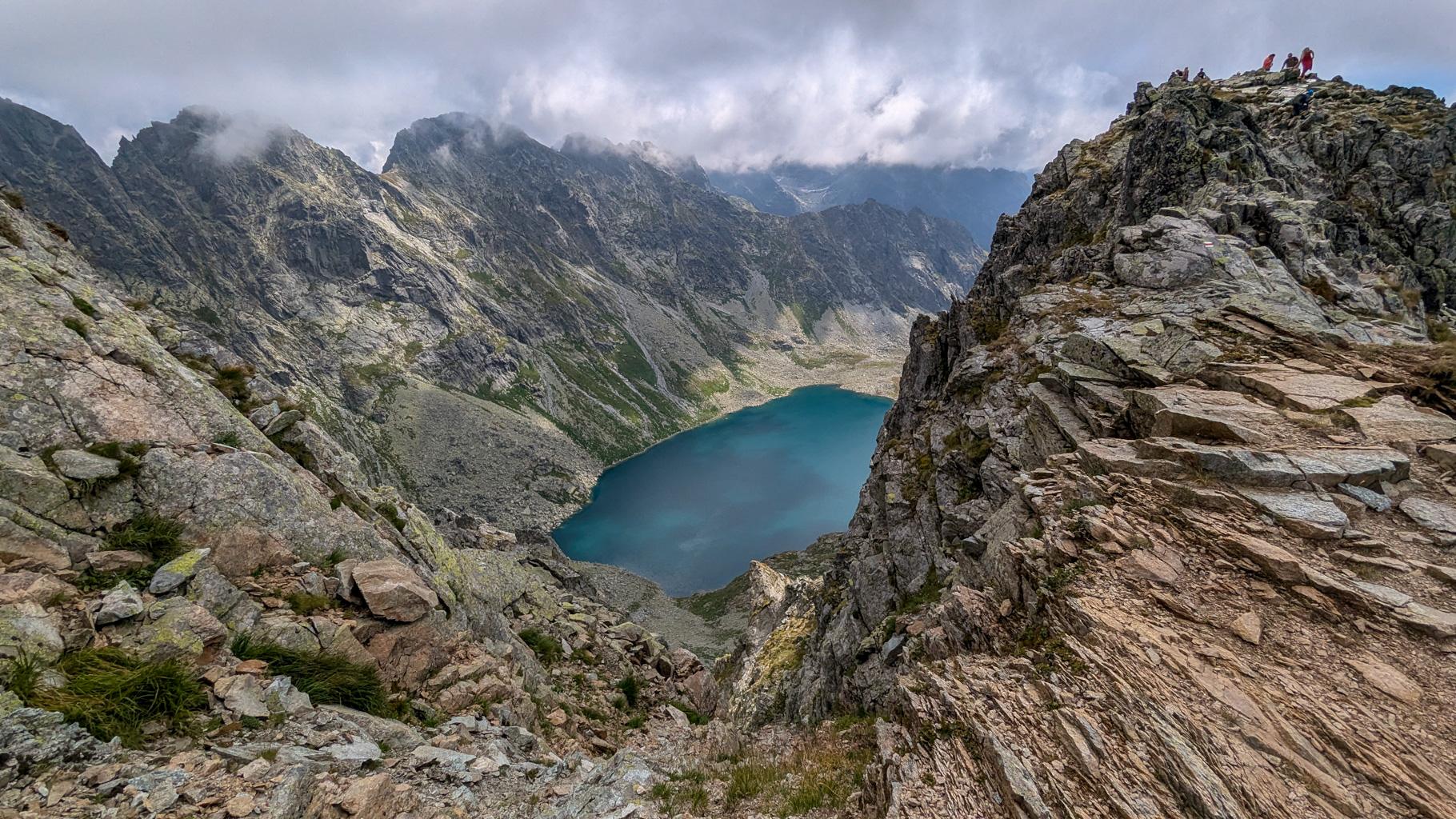 Pohľad na Veľké Hincovo pleso takmer z vrcholu Kôprovského štítu – tyrkysové jazero obklopené skalnými stenami Mengusovskej doliny.