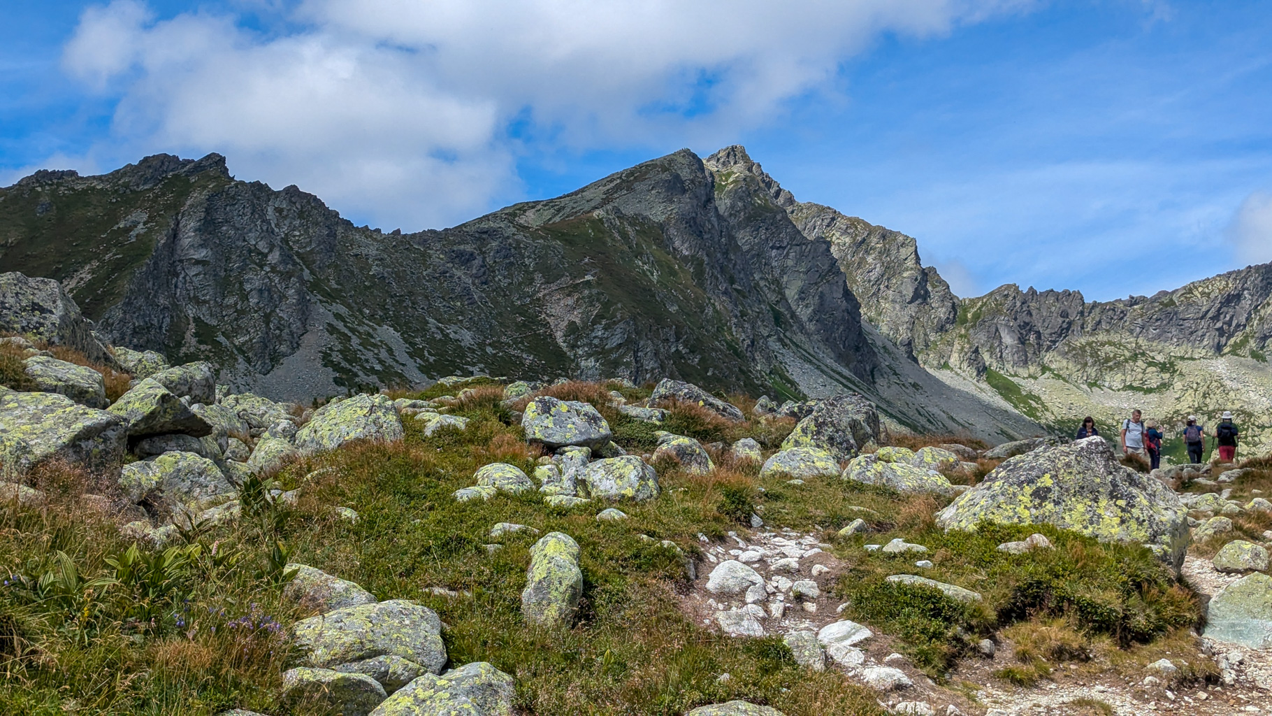 Pohľad na Kôprovský štít počas zostupu – spätný pohľad na skalnatý hrebeň, ktorým vedie turistický chodník na vrchol (2363 m n. m.).