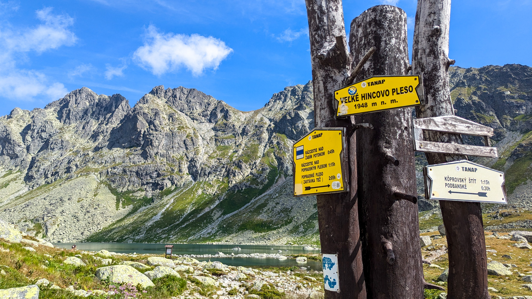 Turistické smerovníky pri Veľkom Hincovom plese (1948 m n. m.), križovatka trás smerom na Kôprovský štít, Podbanské alebo späť na Popradské pleso.