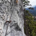 Foto 10: Traverz po skalnej stene s istiacim lanom a výhľadom na zalesnené údolie
