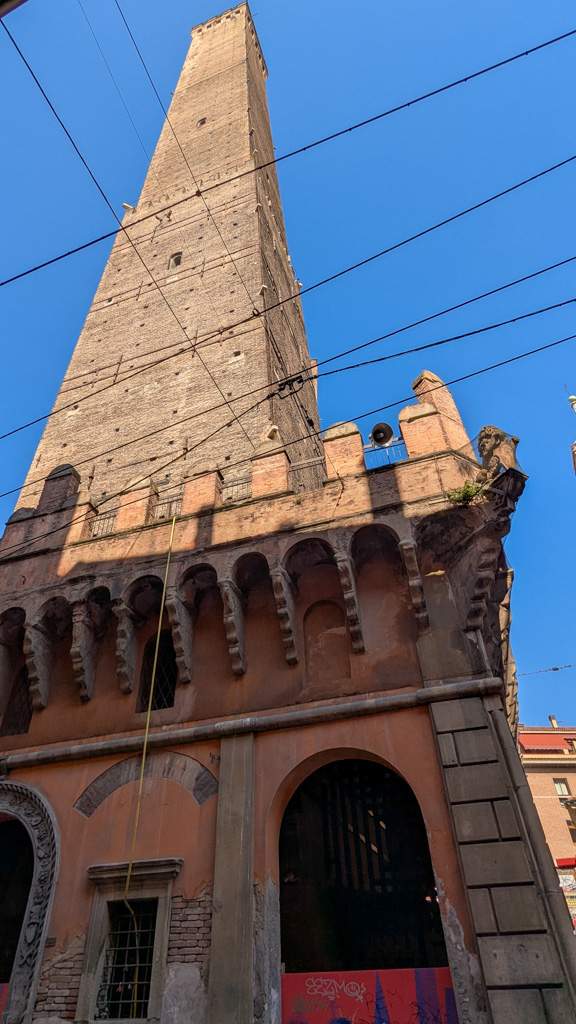 Pohľad na šikmú vežu Torre degli Asinelli, vysokú 97,2 metra, pochádzajúcu z 12. storočia. Je najvyššou stredovekou šikmou vežou v Taliansku a jej vrchol je prístupný po 498 schodoch.