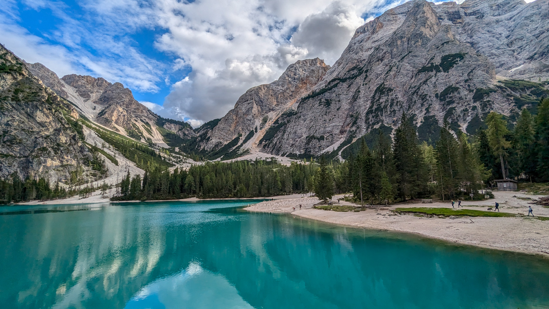 Pohľad na severný cíp Lago di Braies, kde sa často začína okruh okolo jazera. Priezračná voda a dramatické skalné pozadie sú typické pre túto časť Dolomitov.