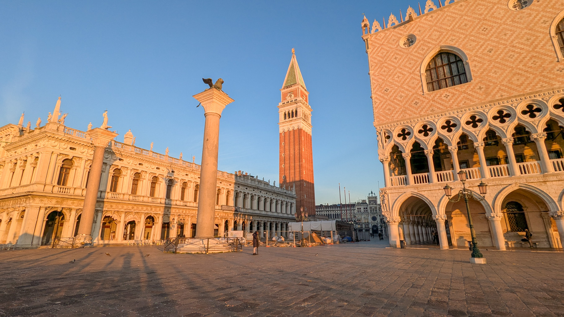 Východ slnka nad Piazzettou San Marco v Benátkach s pohľadom na stĺpy svätého Marka a svätého Teodora.
        